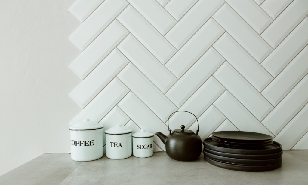 Bilde av kaffe, te og sukker bokser på en kjøkkenbenk i lyse farger